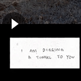 Thumbnail; Screenshot of video with play button. Handwritten text "I AM DIGGING A TUNNEL TO YOU"